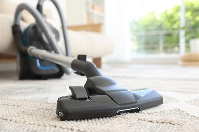 Photo of One vacuum cleaner on floor indoors, closeup. Household appliance