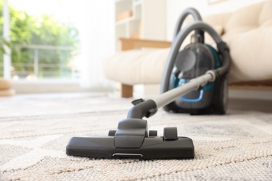 Photo of One vacuum cleaner on floor indoors, closeup. Household appliance