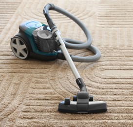 Photo of One vacuum cleaner on floor indoors. Household appliance