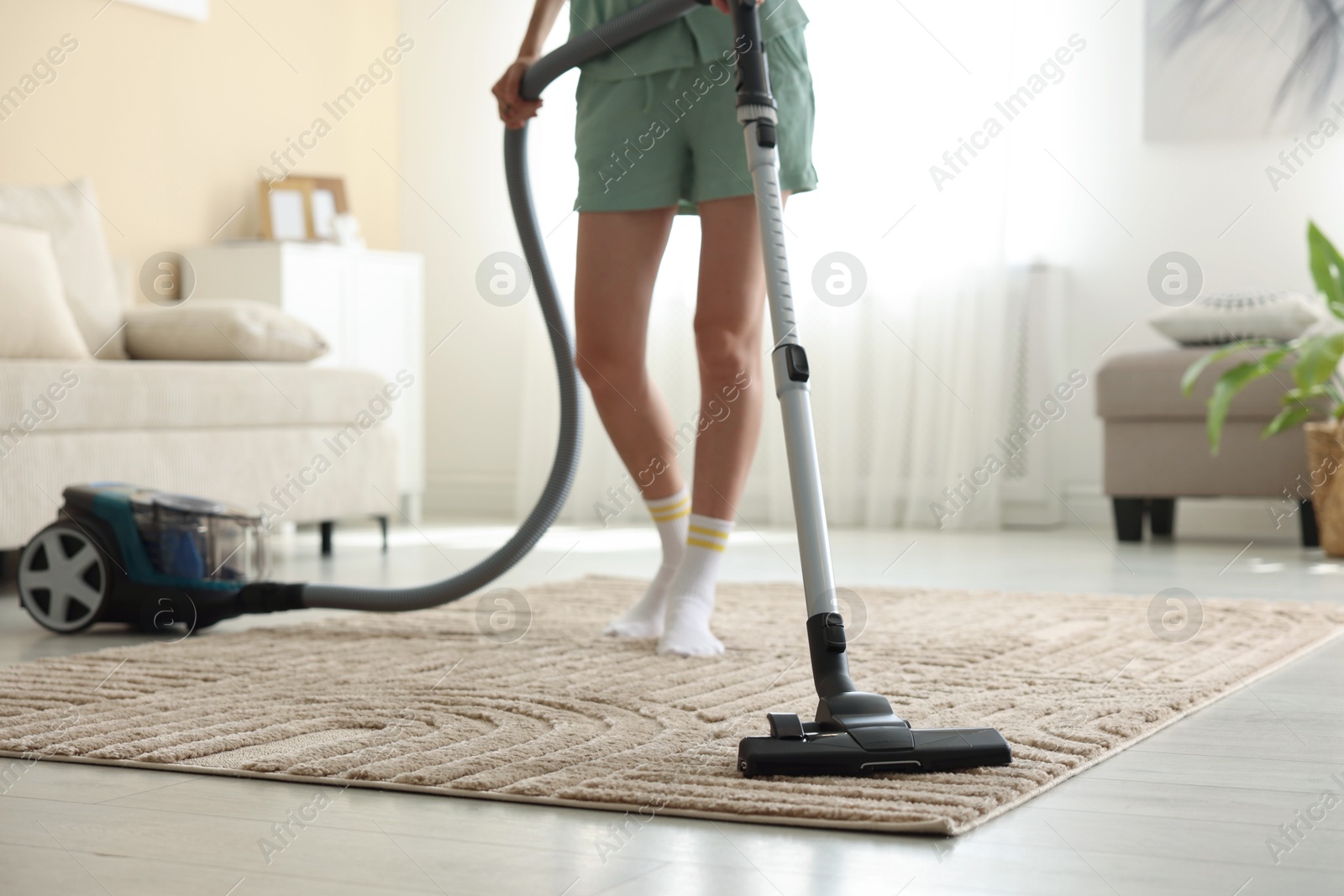 Woman cleaning carpet with vacuum cleaner at home, closeup Photo of Woman cleaning carpet with vacuum cleaner at home, closeup