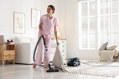 Photo of Woman cleaning floor with vacuum cleaner at home