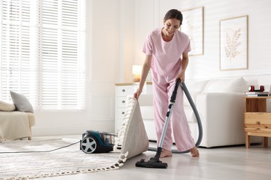 Photo of Woman cleaning floor with vacuum cleaner at home
