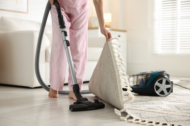 Photo of Woman cleaning floor with vacuum cleaner at home, closeup