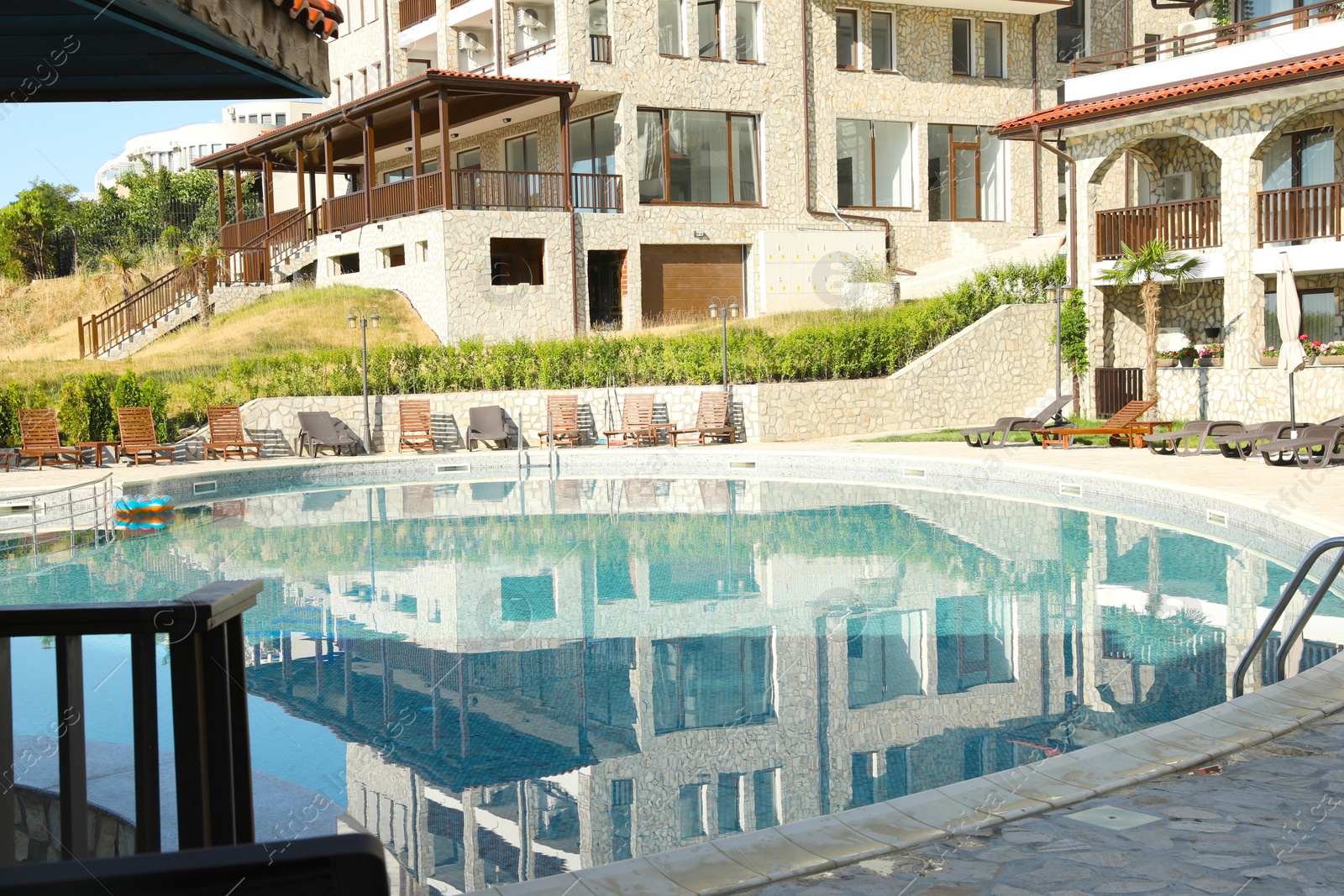 Photo of Outdoor swimming pool and sunbeds near hotel at luxury resort
