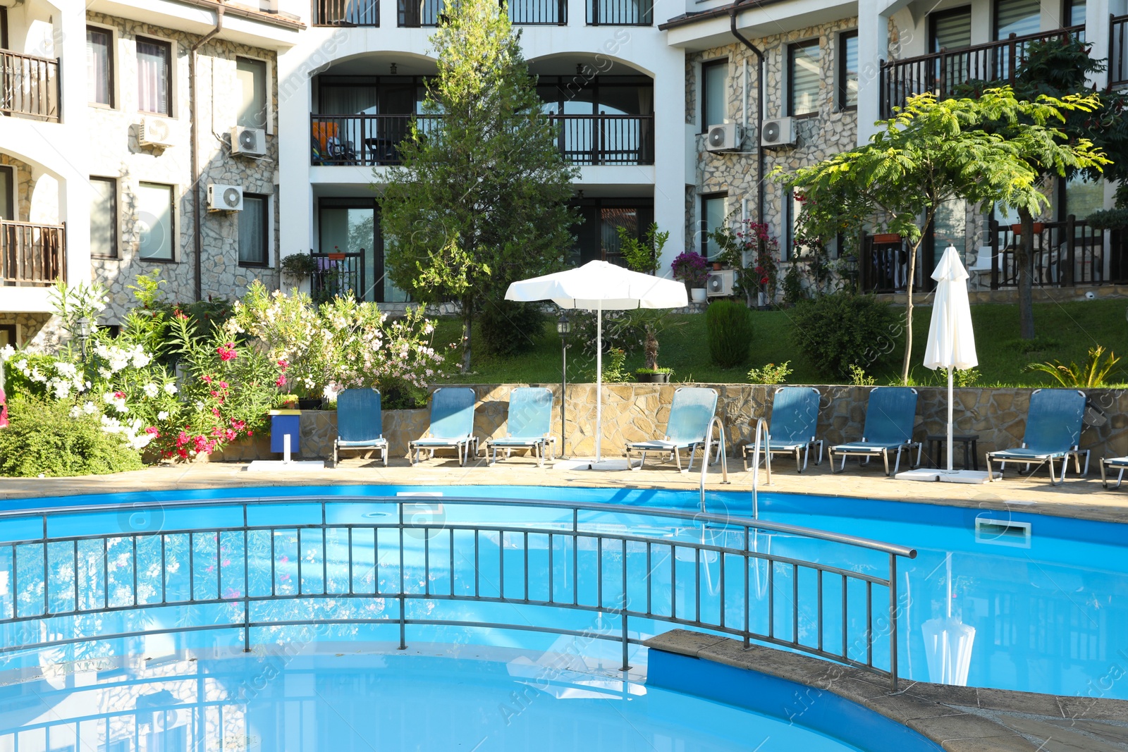 Photo of Outdoor swimming pool and sunbeds near hotel at luxury resort