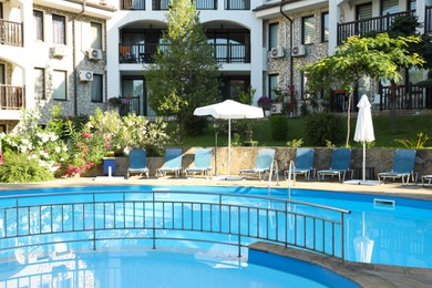 Photo of Outdoor swimming pool and sunbeds near hotel at luxury resort