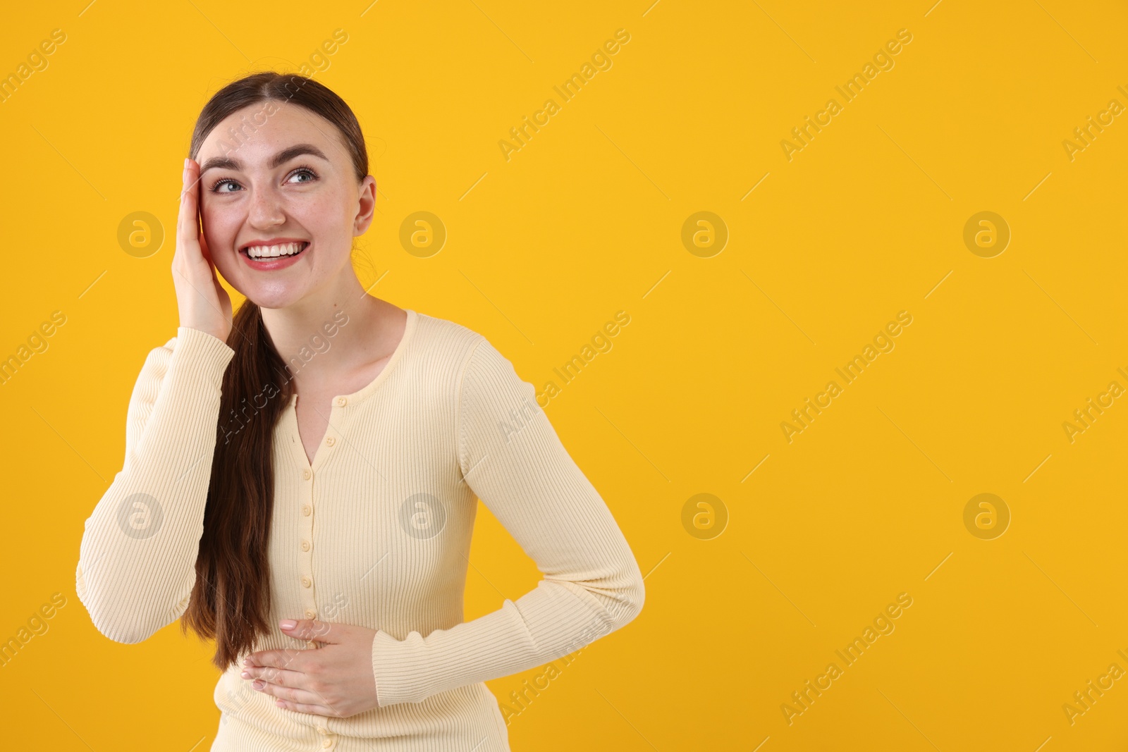 Beautiful woman laughing on yellow background. Space for text Photo of Beautiful woman laughing on yellow background. Space for text