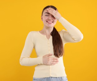 Photo of Beautiful woman laughing on yellow background. Positive emotion
