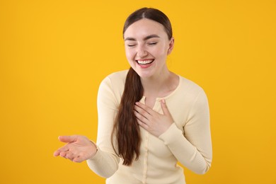 Photo of Beautiful woman laughing on yellow background. Positive emotion