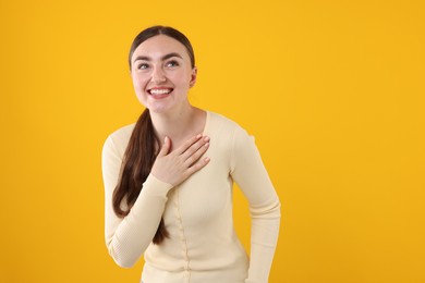 Photo of Beautiful woman laughing on yellow background. Space for text