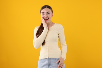 Photo of Beautiful woman laughing on yellow background. Positive emotion