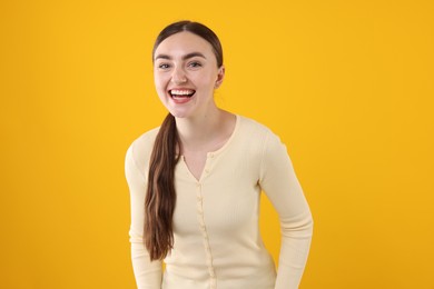 Photo of Beautiful woman laughing on yellow background. Positive emotion