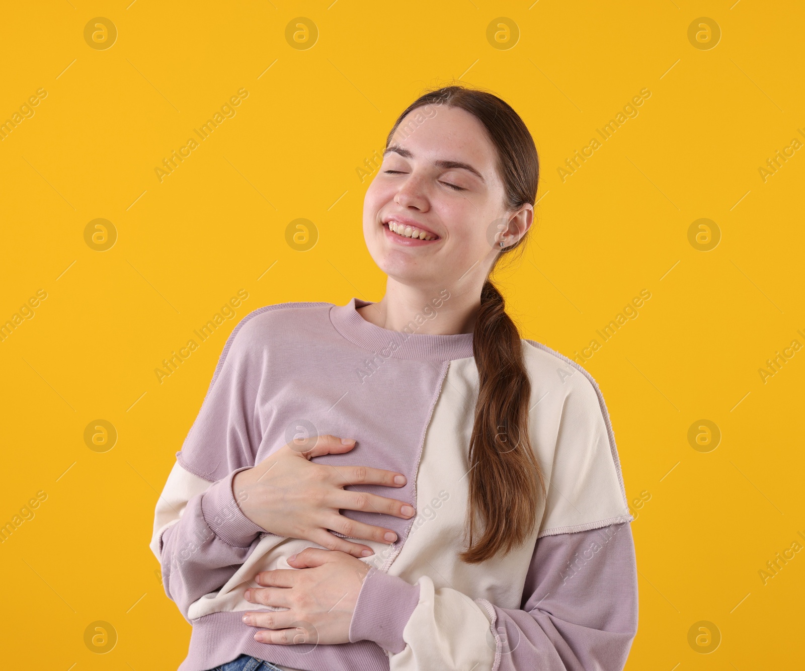 Beautiful woman laughing on yellow background. Positive emotion Photo of Beautiful woman laughing on yellow background. Positive emotion