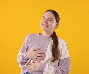 Photo of Beautiful woman laughing on yellow background. Positive emotion