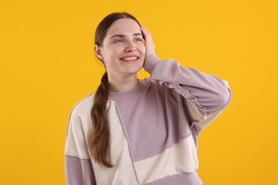 Photo of Beautiful woman laughing on yellow background. Positive emotion