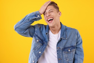 Photo of Handsome man laughing on yellow background. Positive emotion