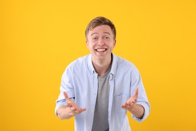 Photo of Handsome man laughing on yellow background. Positive emotion