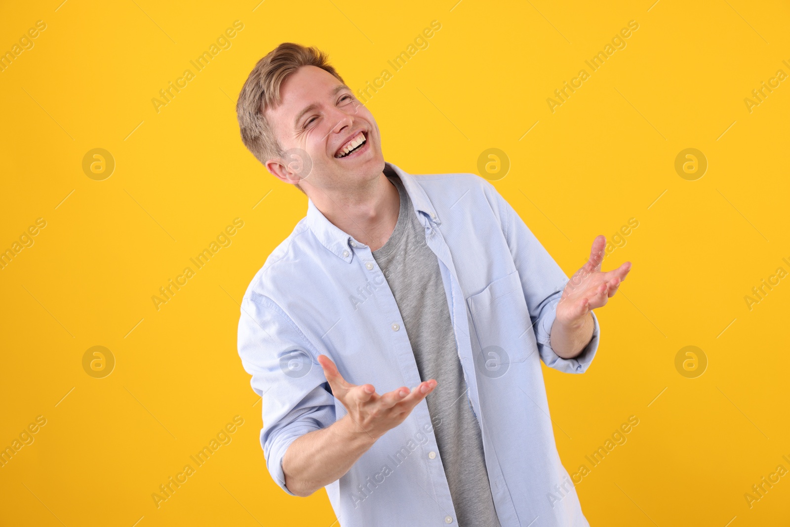 Handsome man laughing on yellow background. Positive emotion Photo of Handsome man laughing on yellow background. Positive emotion