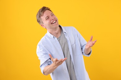 Photo of Handsome man laughing on yellow background. Positive emotion