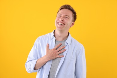 Photo of Handsome man laughing on yellow background. Positive emotion