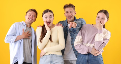 Photo of Friends laughing on yellow background. Positive emotion