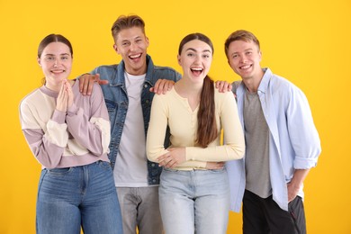Photo of Friends laughing on yellow background. Positive emotion