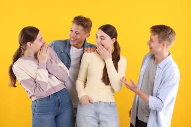 Photo of Friends laughing on yellow background. Positive emotion