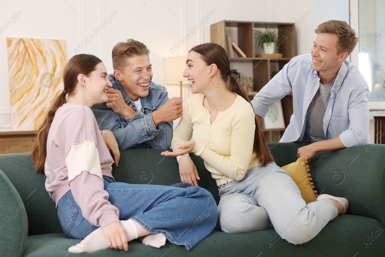 Friends laughing on sofa indoors. Positive emotion Photo of Friends laughing on sofa indoors. Positive emotion