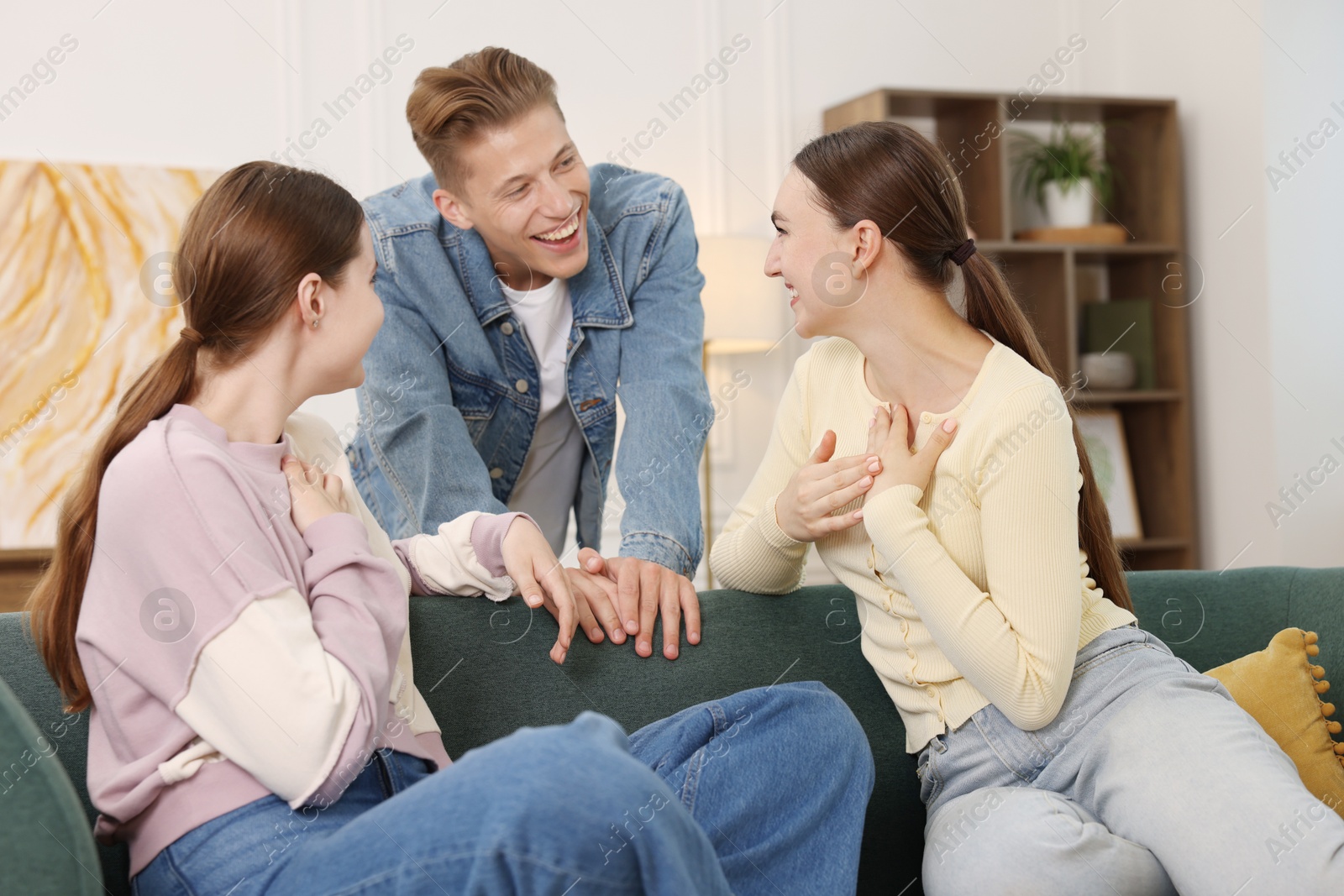 Friends laughing on sofa indoors. Positive emotion Photo of Friends laughing on sofa indoors. Positive emotion