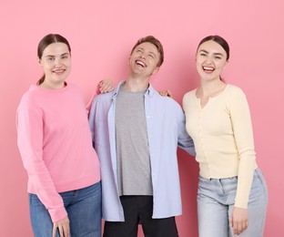 Photo of Friends laughing on pink background. Positive emotion