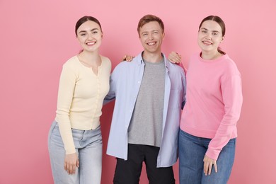 Photo of Friends laughing on pink background. Positive emotion