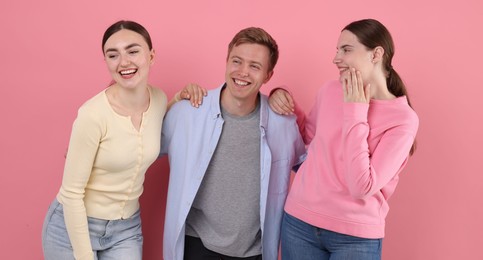 Photo of Friends laughing on pink background. Positive emotion