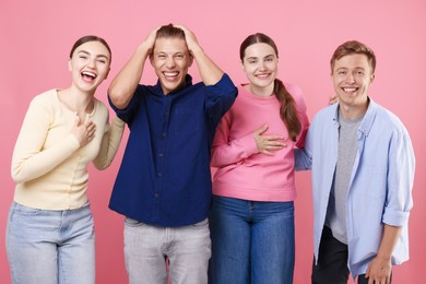Photo of Friends laughing on pink background. Positive emotion