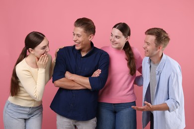 Photo of Friends laughing on pink background. Positive emotion