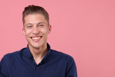Photo of Handsome man laughing on pink background. Space for text