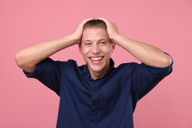Photo of Handsome man laughing on pink background. Positive emotion
