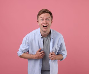Photo of Handsome man laughing on pink background. Positive emotion