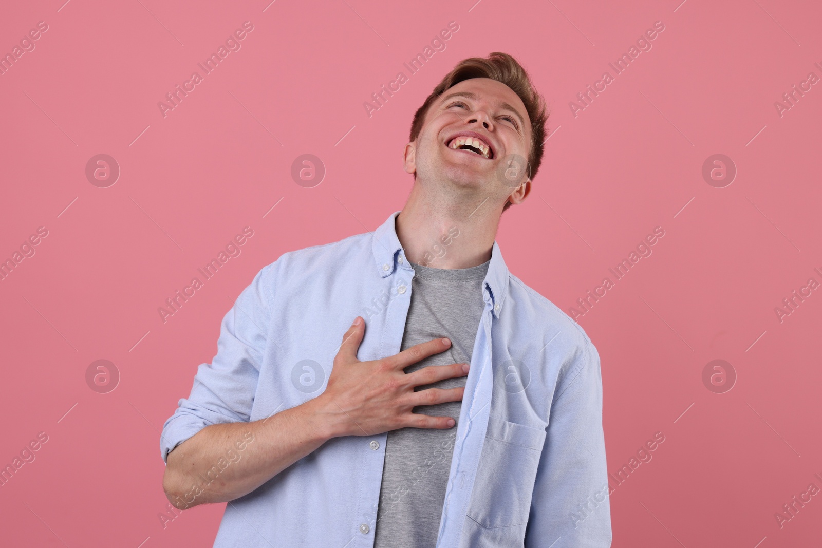 Handsome man laughing on pink background. Positive emotion Photo of Handsome man laughing on pink background. Positive emotion