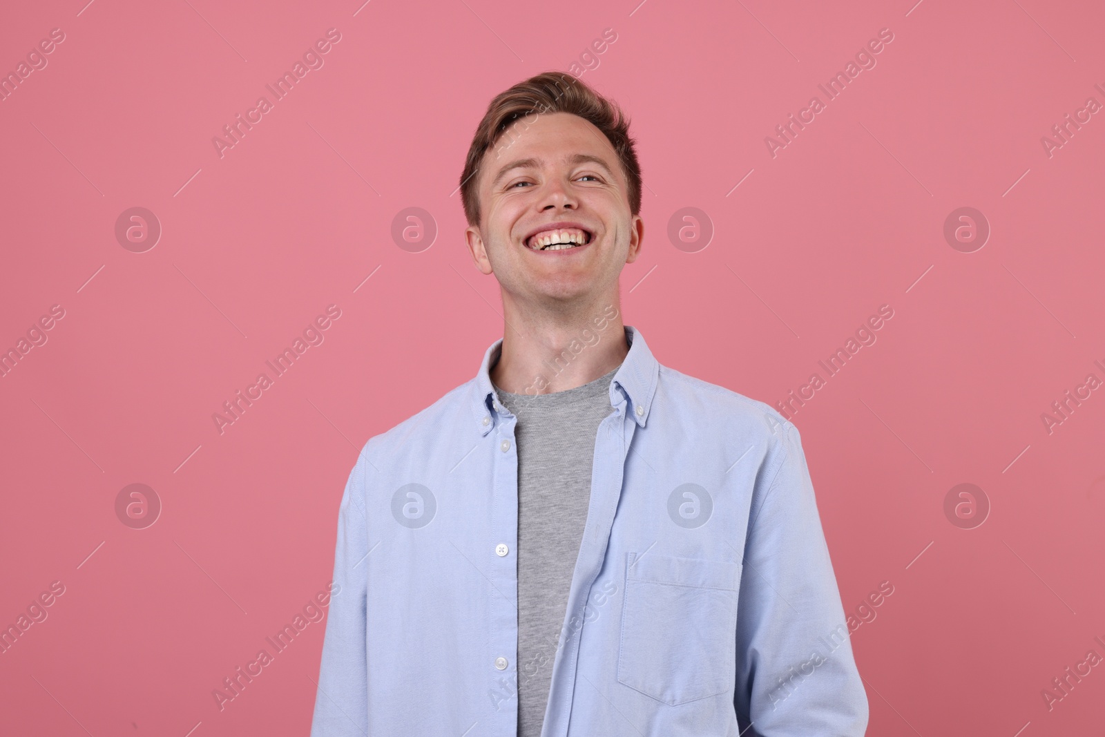 Handsome man laughing on pink background. Positive emotion Photo of Handsome man laughing on pink background. Positive emotion