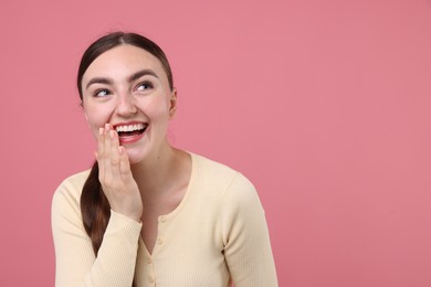 Photo of Beautiful woman laughing on pink background. Space for text