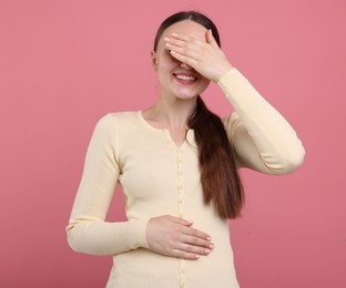 Photo of Beautiful woman laughing on pink background. Positive emotion