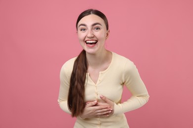Photo of Beautiful woman laughing on pink background. Positive emotion