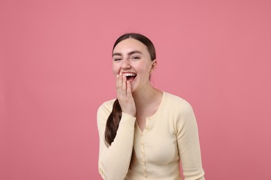 Photo of Beautiful woman laughing on pink background. Positive emotion