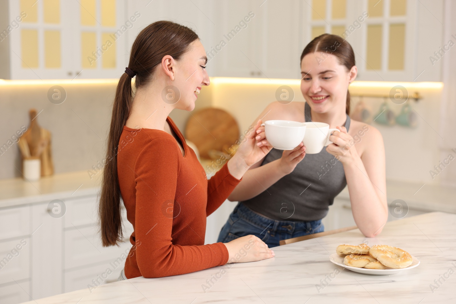 Women with coffee laughing in kitchen. Positive emotion Photo of Women with coffee laughing in kitchen. Positive emotion