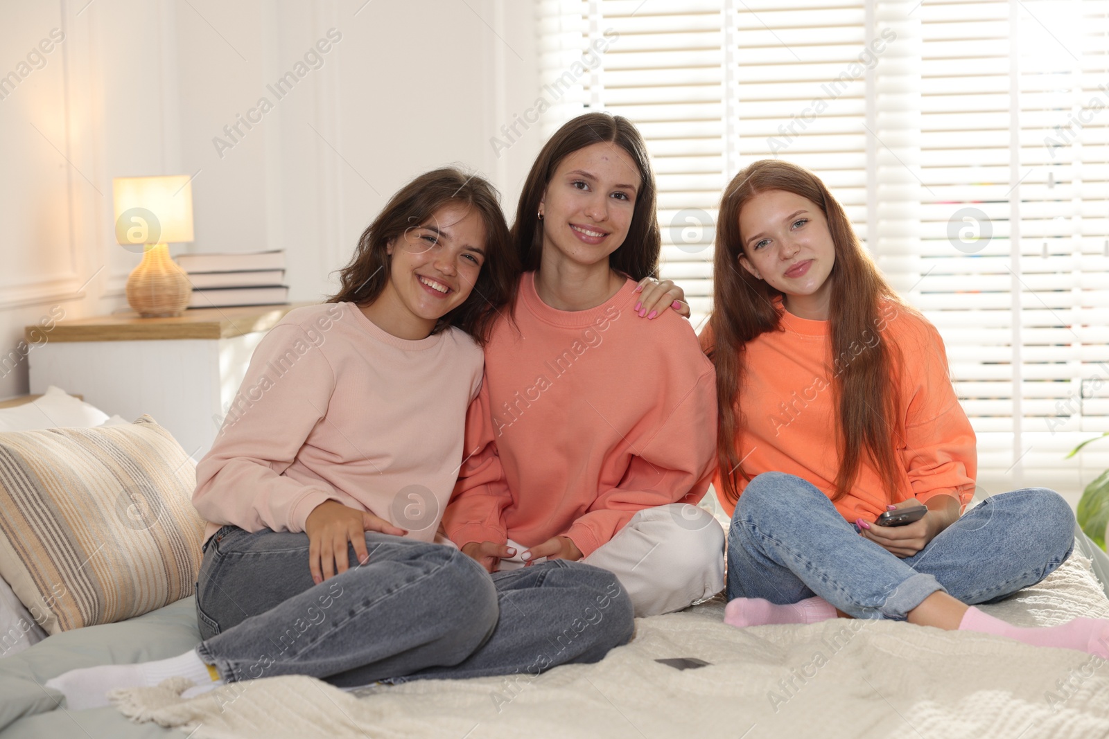 Portrait of happy friends on bed at home Photo of Portrait of happy friends on bed at home