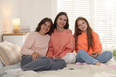 Photo of Portrait of happy friends on bed at home