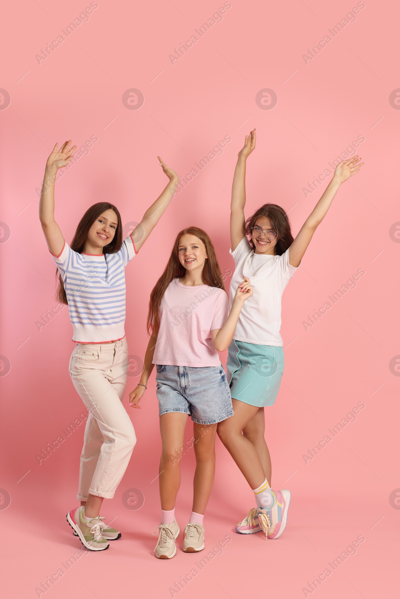 Photo of Portrait of happy friends on pink background