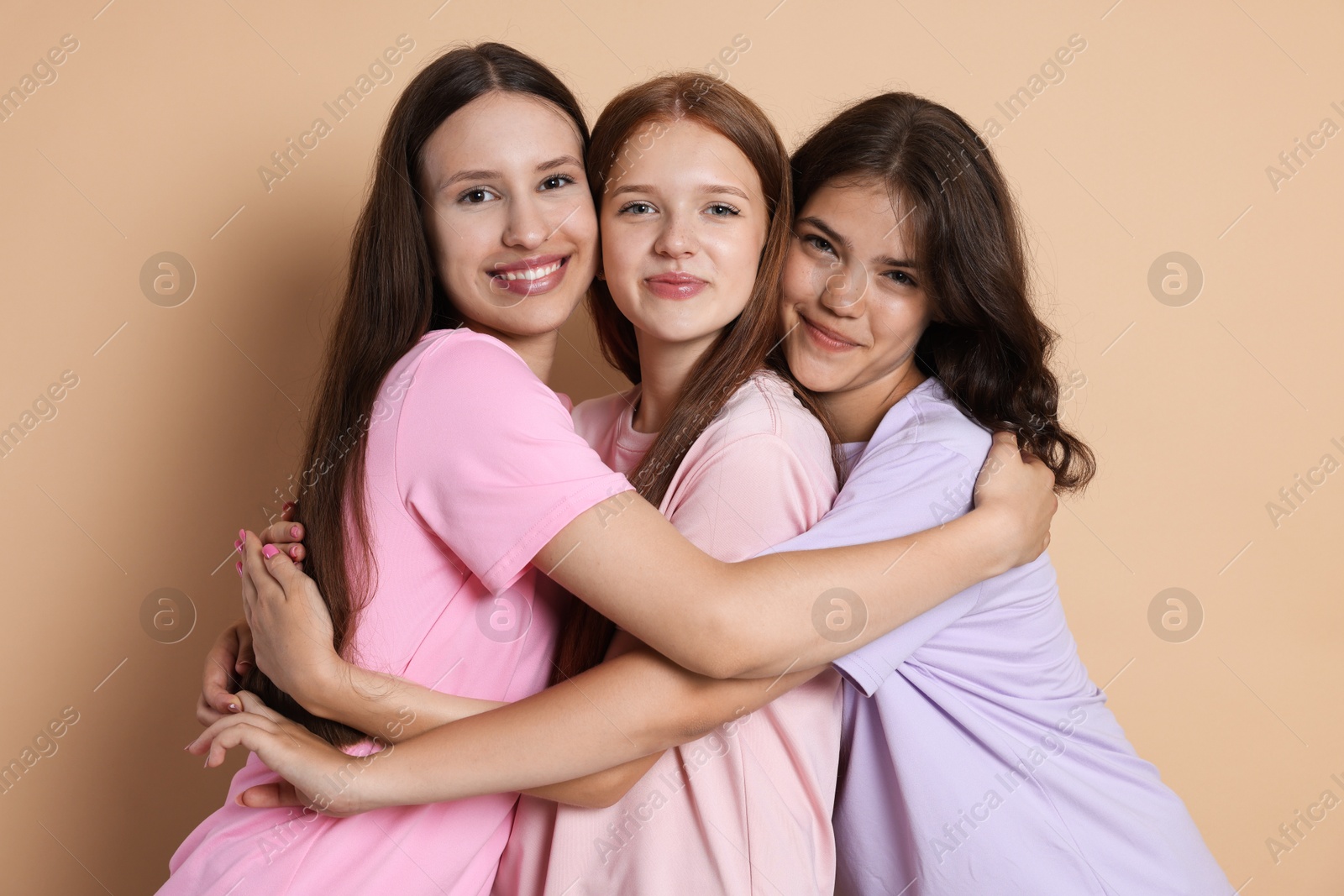 Portrait of happy friends on beige background Photo of Portrait of happy friends on beige background
