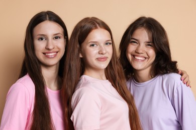 Photo of Portrait of happy friends on beige background
