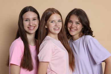 Photo of Portrait of happy friends on beige background